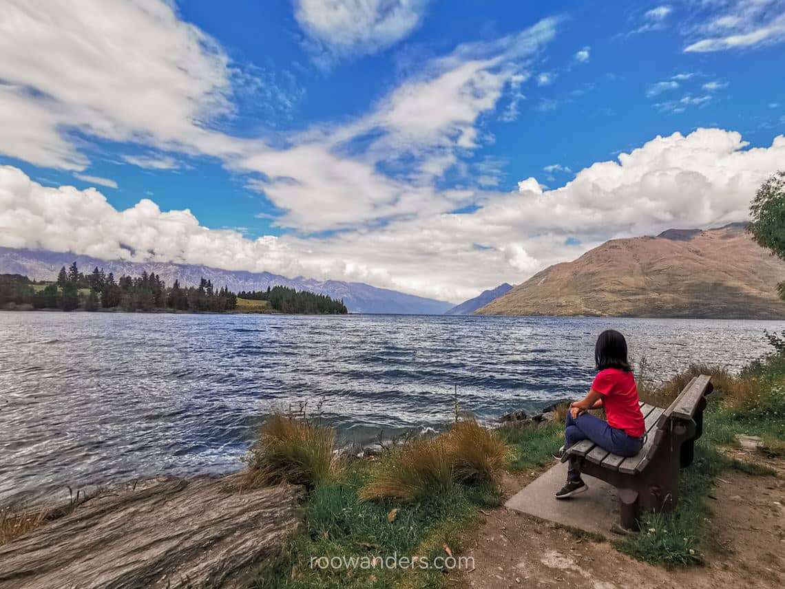 Sitting on a bench by Lake Wakatipu, New Zealand - RooWanders